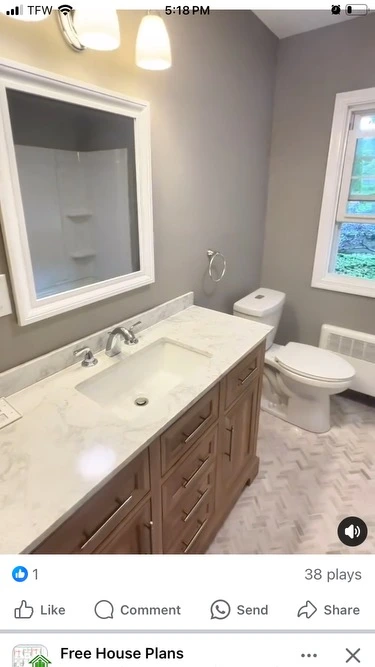 Second bathroom with oak vanity, marble countertop, and herringbone tile floor